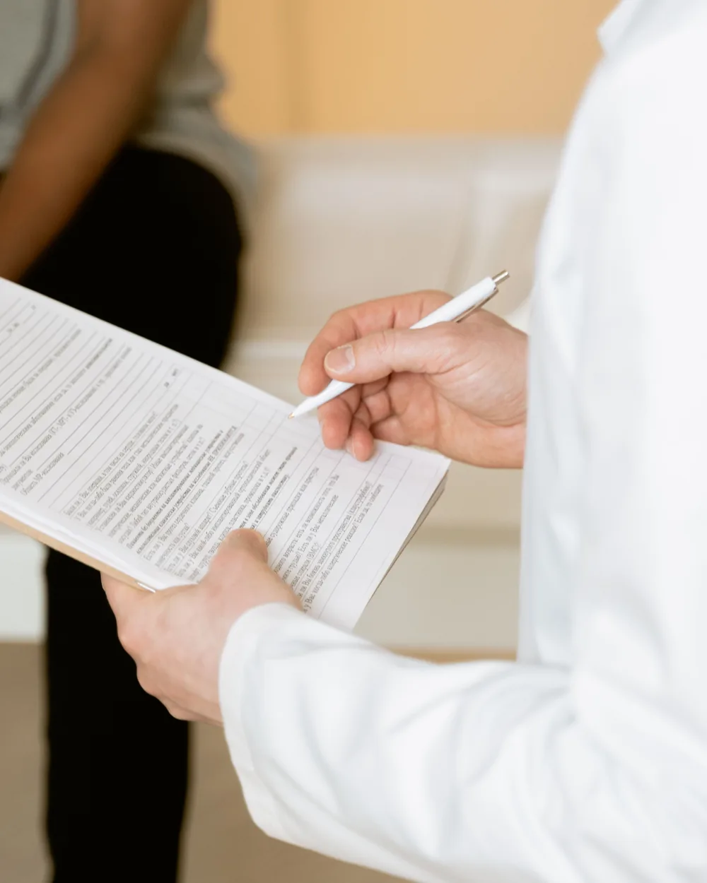 Anonymous hands and a health form during a clinical consultation