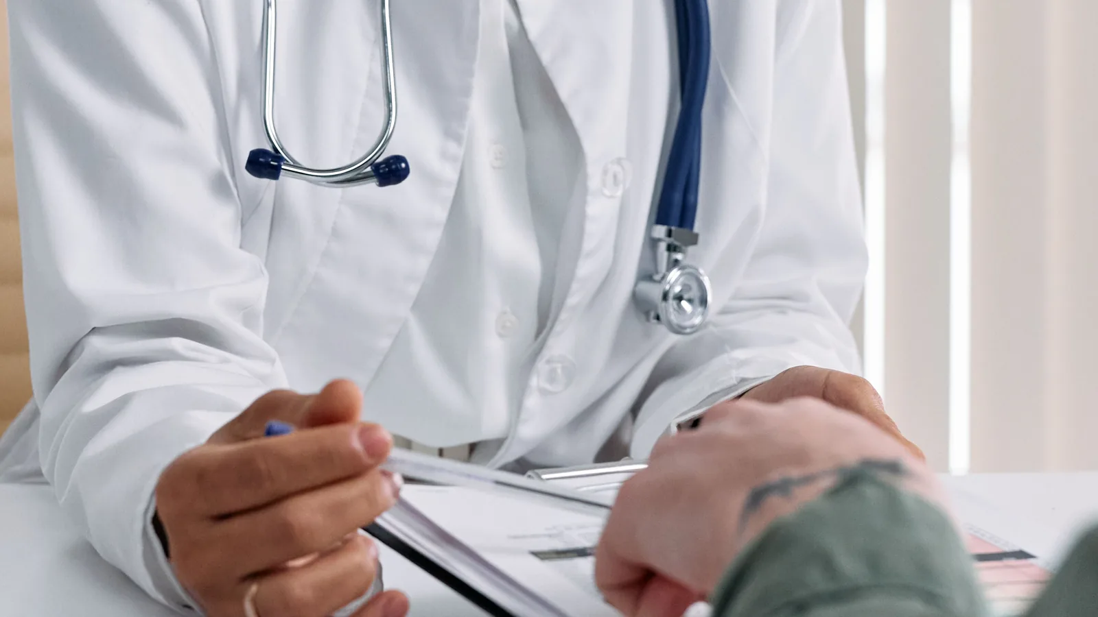 Hands and health documents during a private clinical consultation