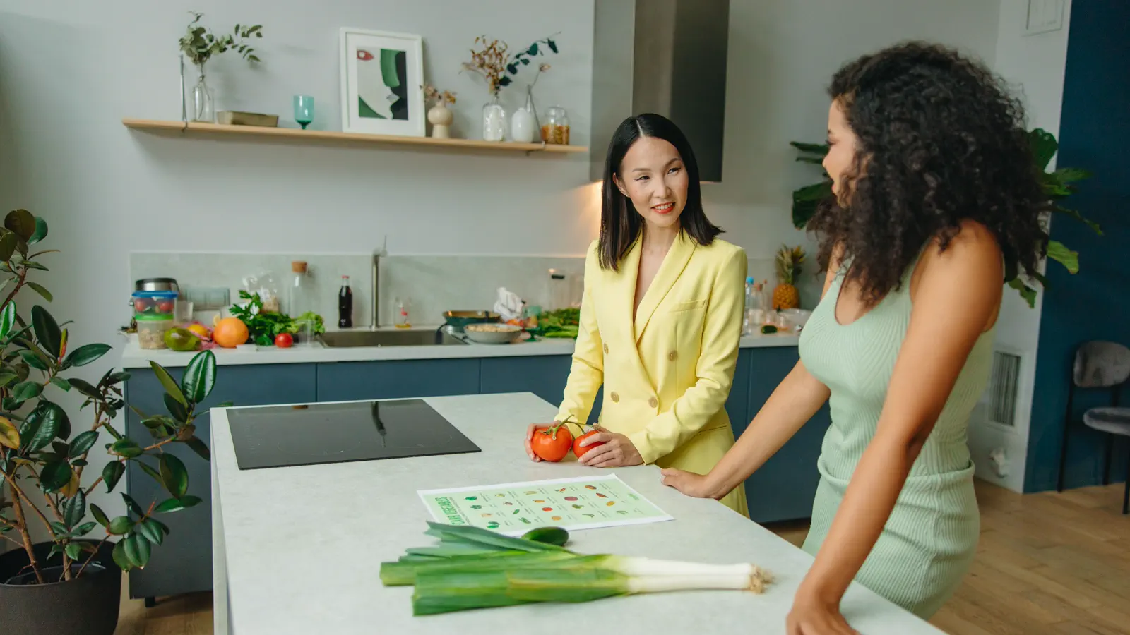 Two adults discuss vegetables and a nutrition guide in a kitchen