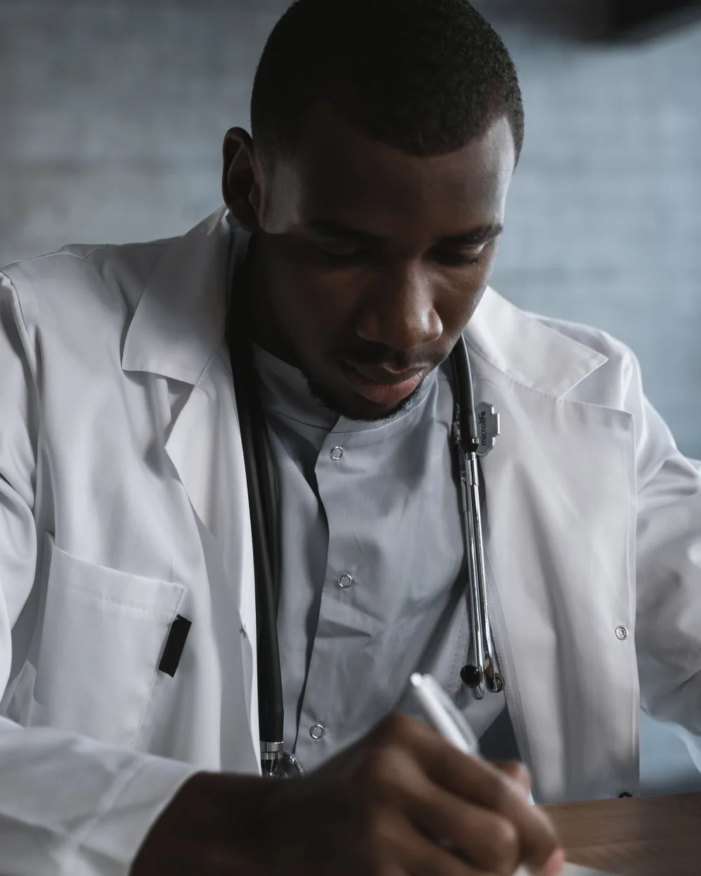 Healthcare professional writing notes at a desk